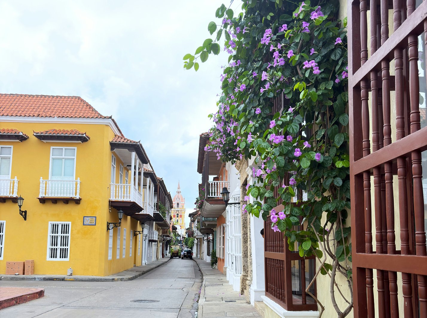 Colorful colonial street with flowering vines Walled City Cartagena Colombia